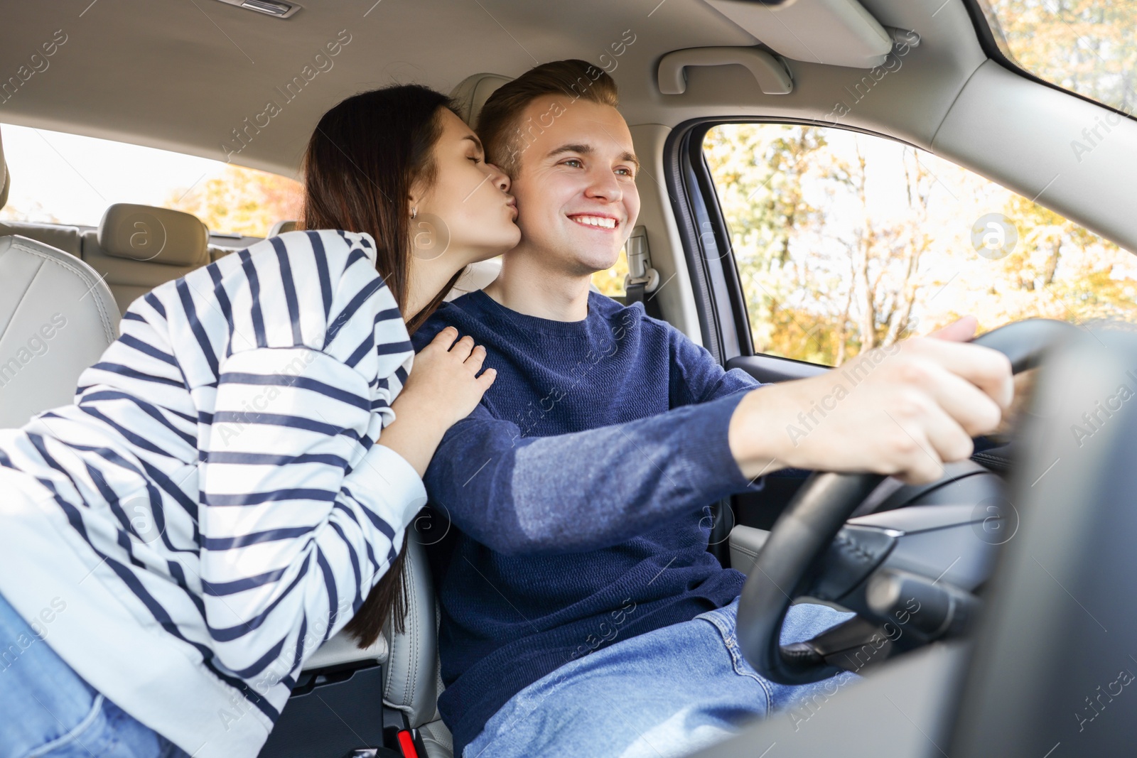 Photo of Happy young couple travelling together by car