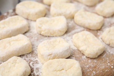Photo of Making lazy dumplings. Cut dough and flour on wooden board, closeup