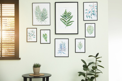 Photo of Living room interior with paintings of tropical leaves on white wall