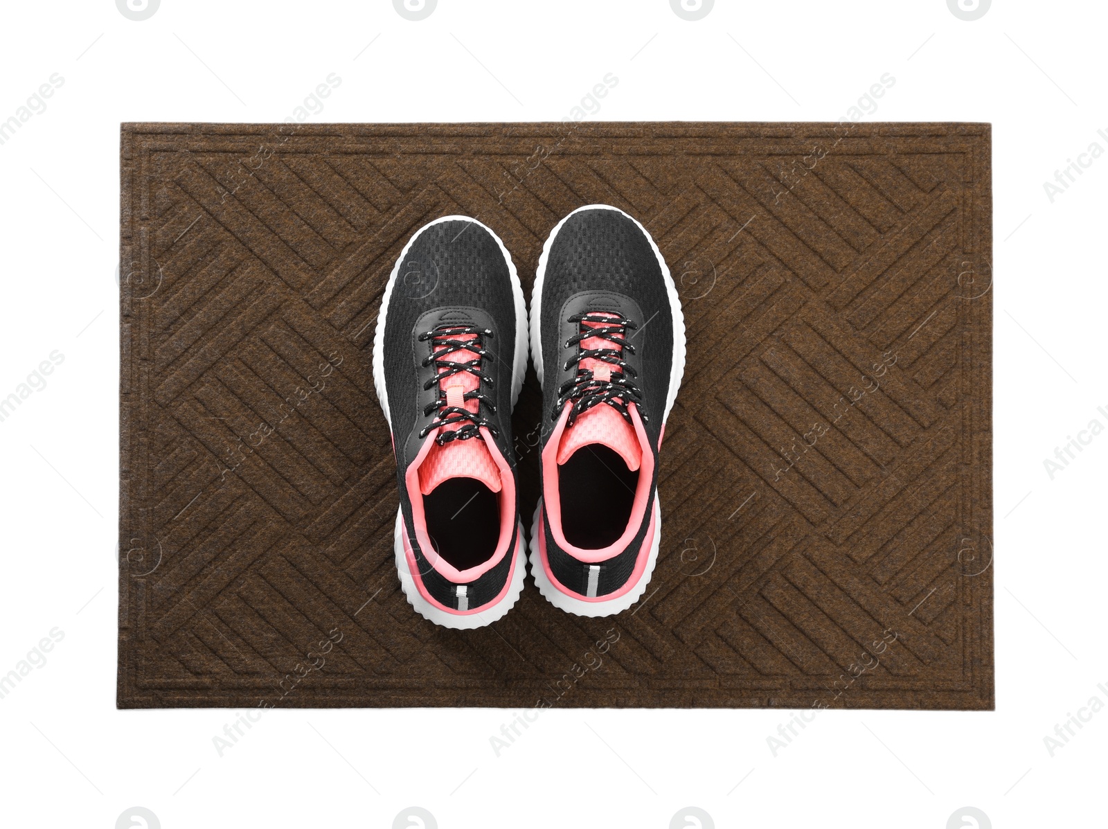 Photo of New clean door mat with shoes on white background, top view