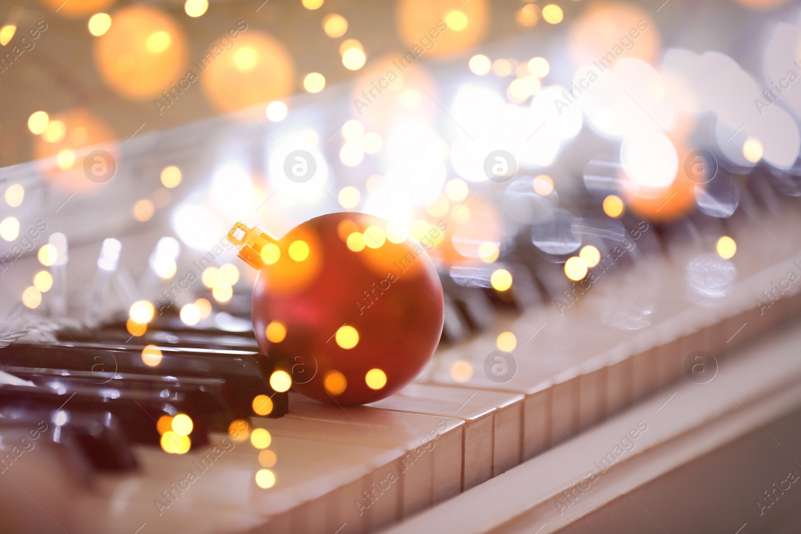 Image of Christmas and New Year music. Piano with festive ball, bokeh effect
