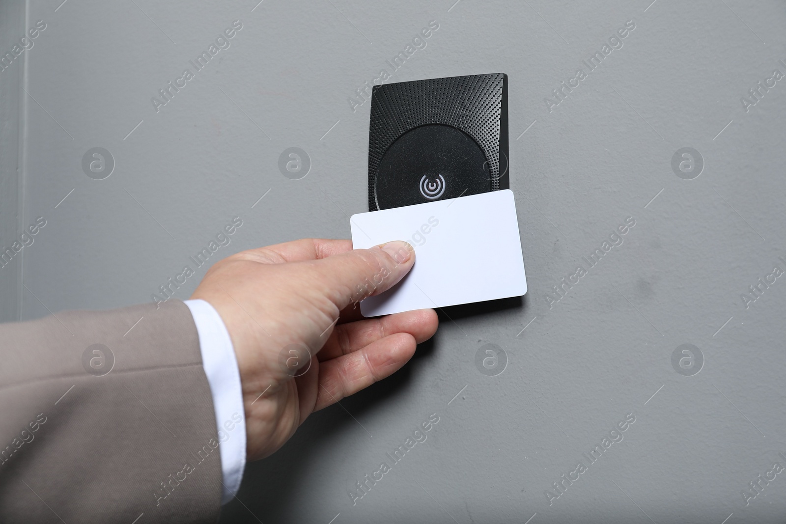 Photo of Man opening magnetic door lock with key card, closeup. Home security