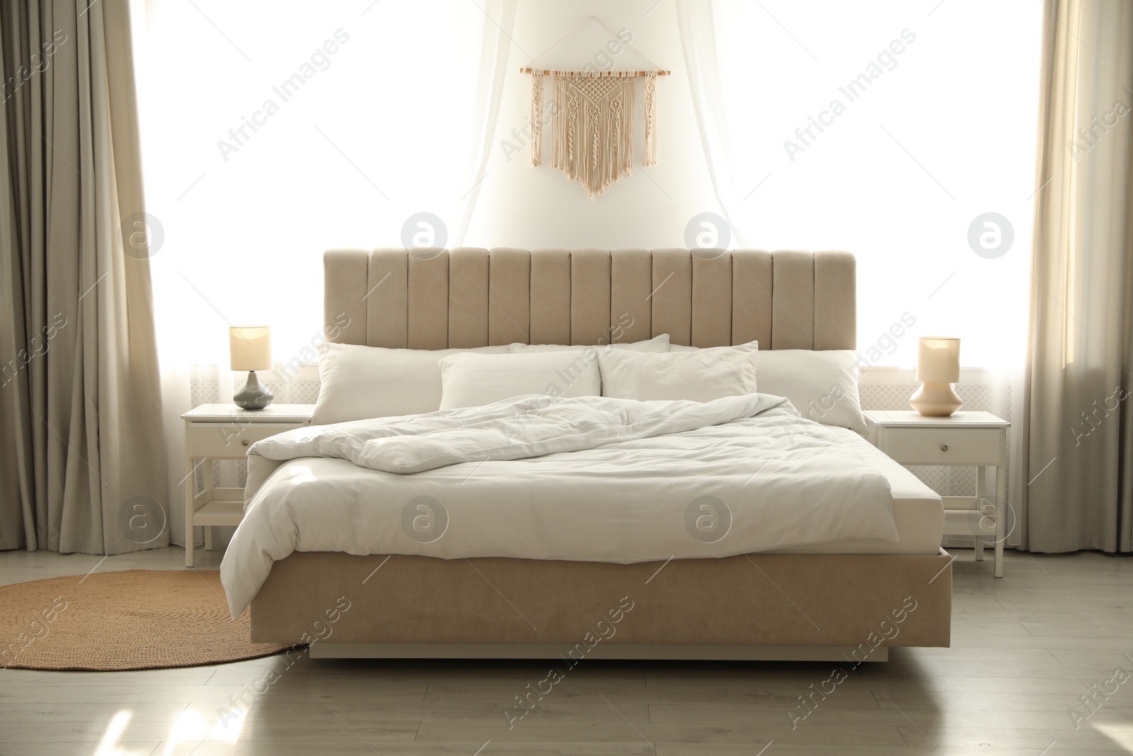 Photo of Comfortable bed with soft blanket in stylish room interior