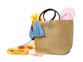 Stylish bag with beach accessories isolated on white