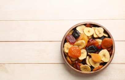 Photo of Mix of delicious dried fruits on white wooden table, top view. Space for text