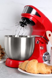 Photo of Modern red stand mixer, croissant and cookies on light gray marble table
