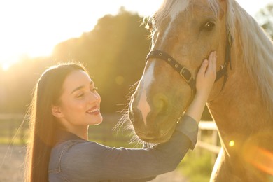 Photo of Beautiful woman with adorable horse outdoors on sunny day. Lovely domesticated pet