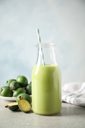 Photo of Fresh feijoa smoothie and fresh fruits on grey table