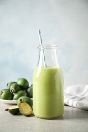 Fresh feijoa smoothie and fresh fruits on grey table