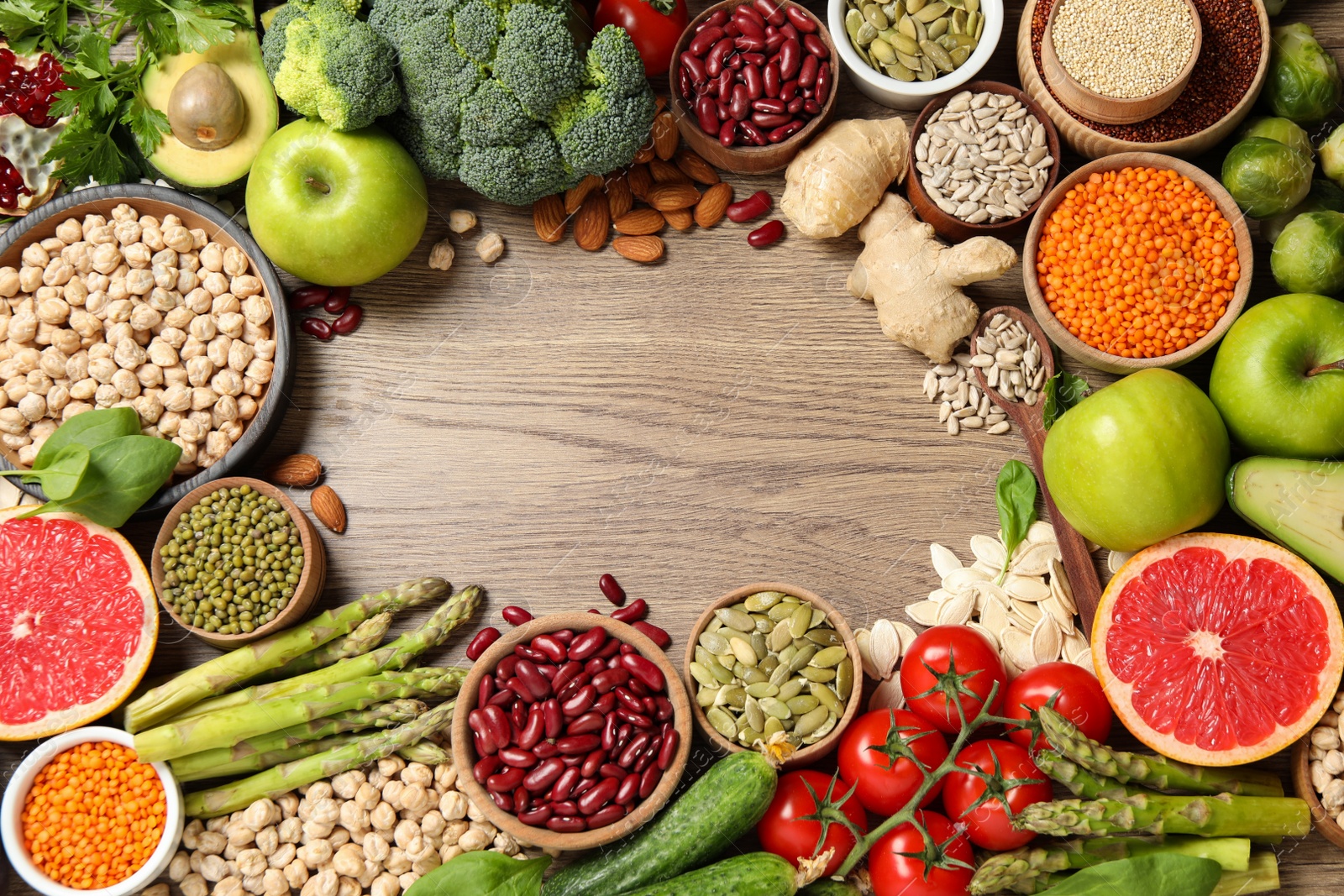 Photo of Frame of fresh vegetables, fruits and seeds on wooden table, flat lay. Space for text