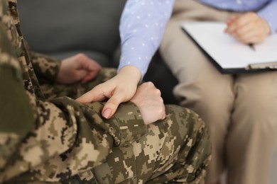 Photo of Psychotherapist working with military woman in office, closeup