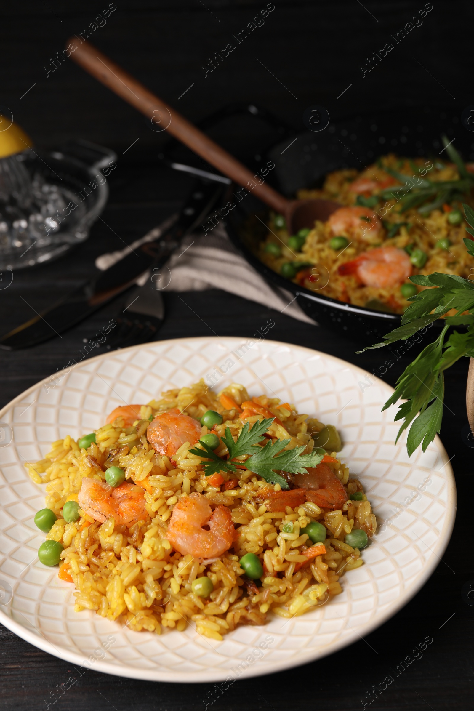 Photo of Tasty rice with shrimps and vegetables on dark table. Space for text