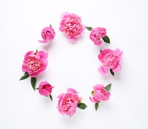 Frame made of fragrant peonies on white background, top view with space for text. Beautiful spring flowers