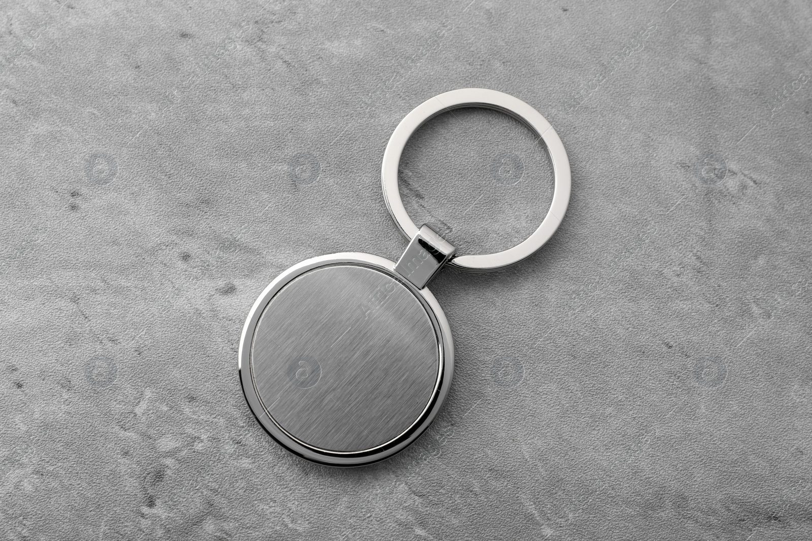 Photo of Metallic keychain on grey background, top view