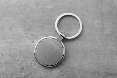 Metallic keychain on grey background, top view