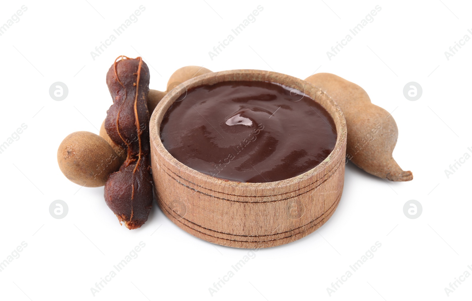Bowl of tamarind sauce and fresh pods isolated on white Photo of Bowl of tamarind sauce and fresh pods isolated on white
