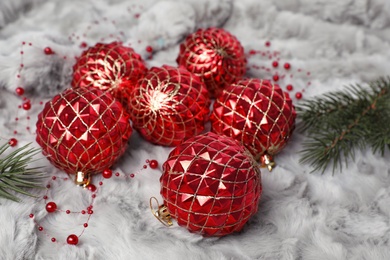 Photo of Beautiful Christmas baubles and fir tree branches on white fur