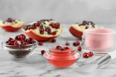 Photo of Homemade cosmetic products and fresh pomegranate on white marble table. DIY beauty recipe