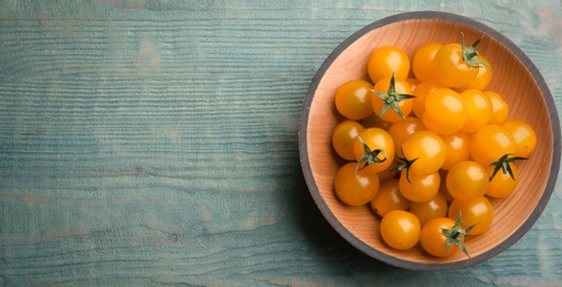 Photo of Ripe yellow tomatoes on light blue wooden table, top view