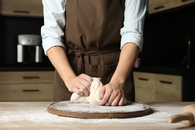 Female baker preparing bread dough at table, closeup