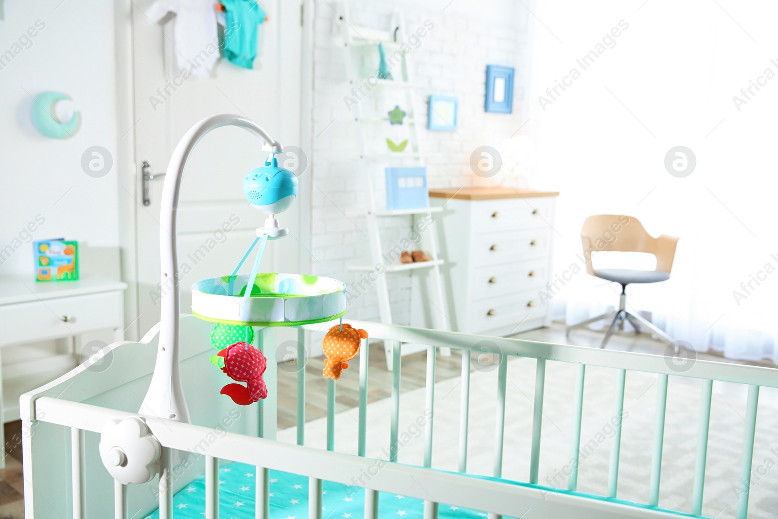 Photo of Cozy crib in light baby room interior