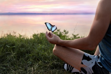 Man meditating near river, closeup. Space for text