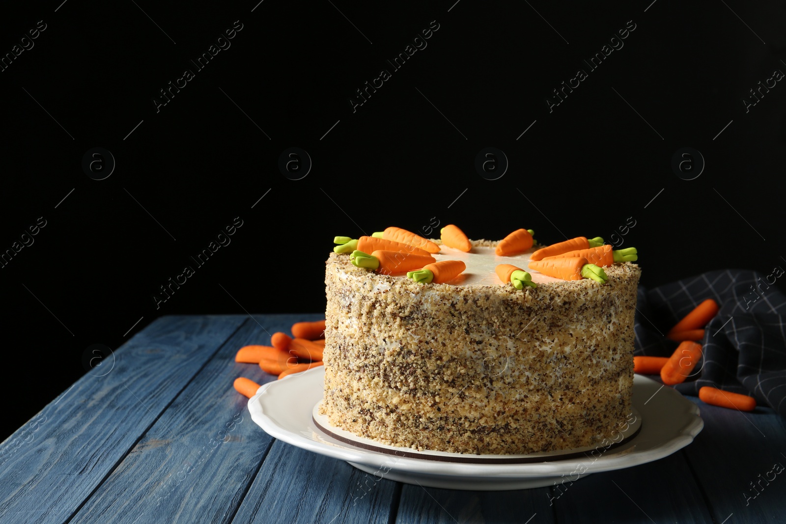 Photo of Composition with delicious carrot cake on blue wooden table against black background, space for text