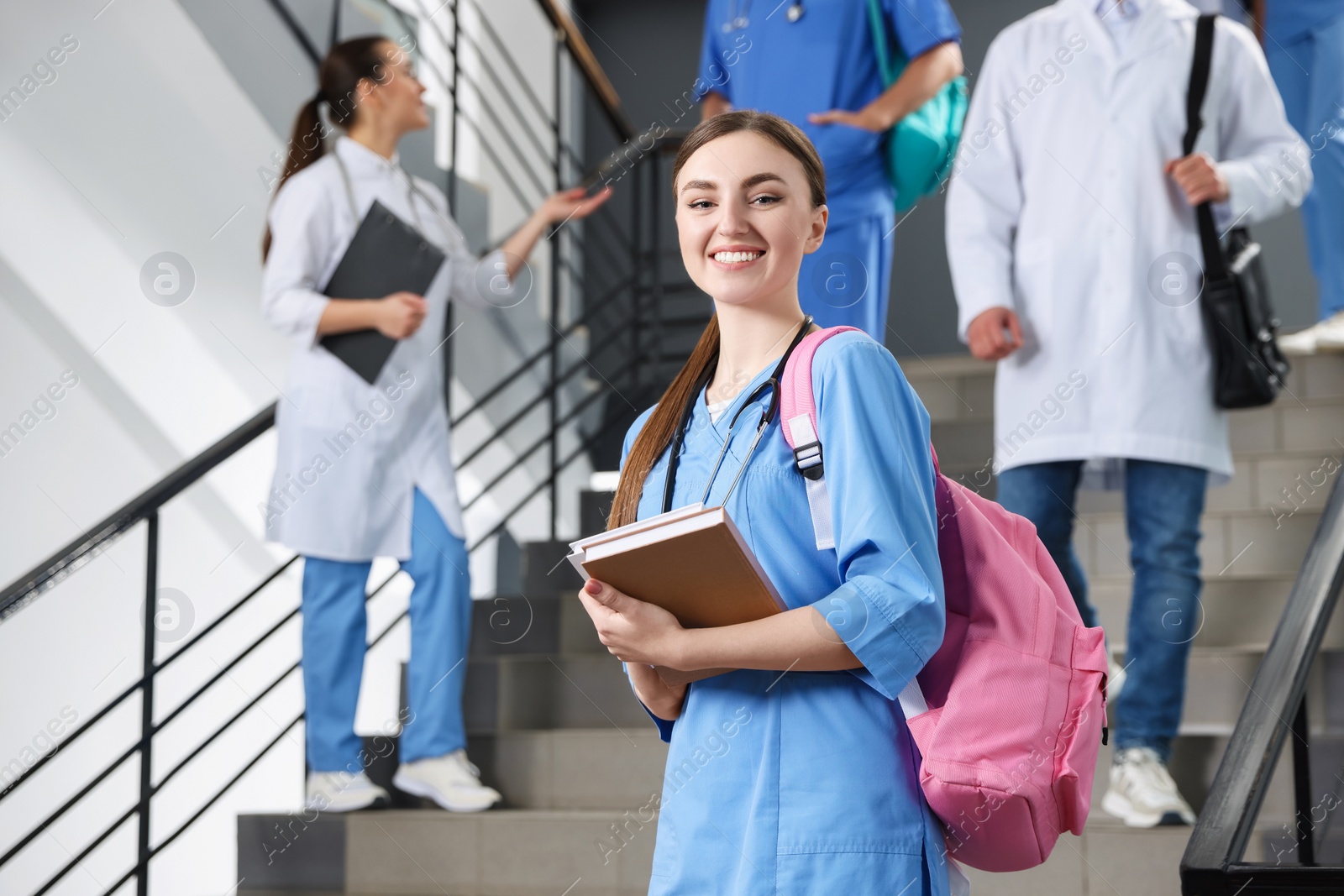 Photo of Portrait of medical student with books on staircase in college, space for text