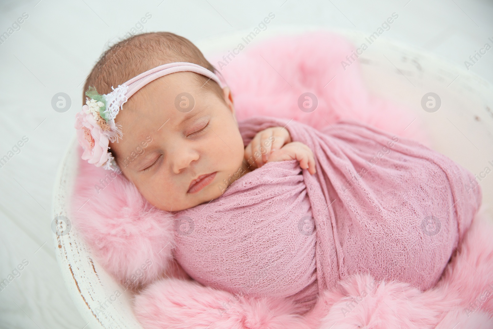 Photo of Adorable newborn girl lying in baby nest, closeup