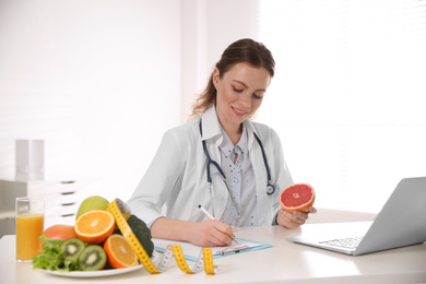 Photo of Female nutritionist working at desk in office