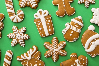 Different Christmas gingerbread cookies on green background, flat lay