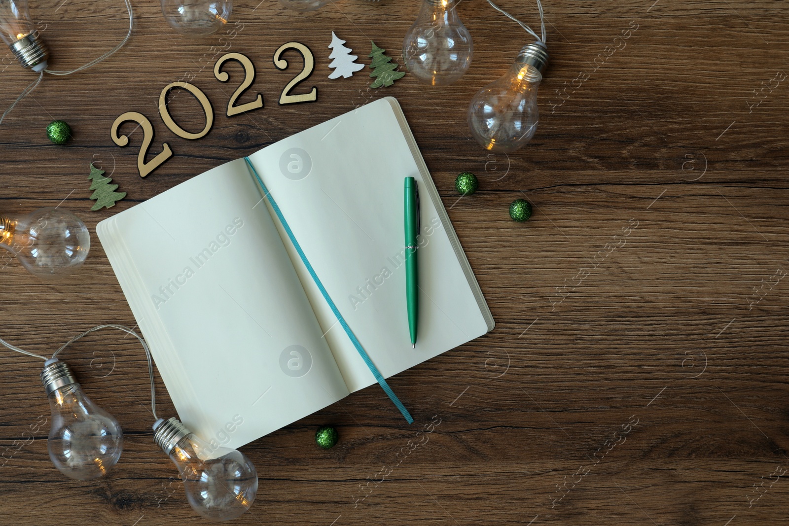 Photo of Open planner and Christmas decor on wooden background, flat lay. 2022 New Year aims