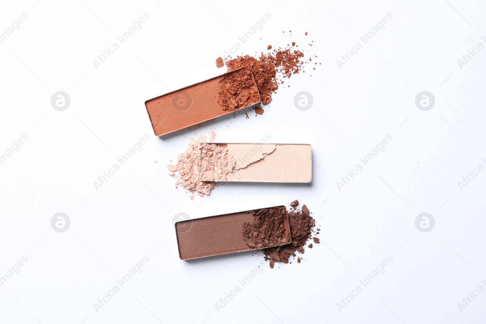 Photo of Different crushed eye shadows on white background, flat lay. Professional makeup product