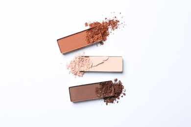 Different crushed eye shadows on white background, flat lay. Professional makeup product