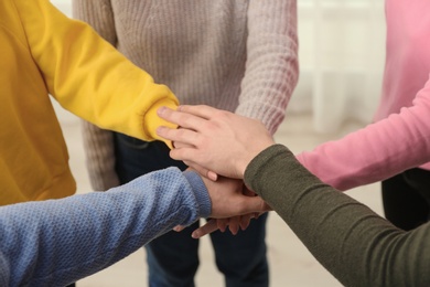 Group of people holding their hands together on blurred background, closeup