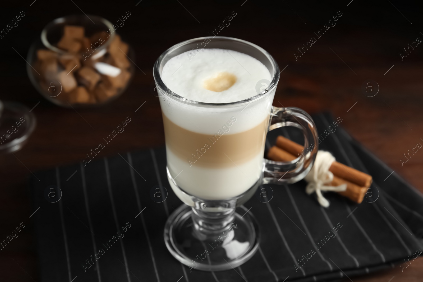 Photo of Delicious latte macchiato and cinnamon on table