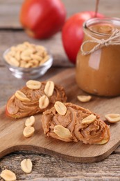 Photo of Fresh apples with peanut butter on wooden table