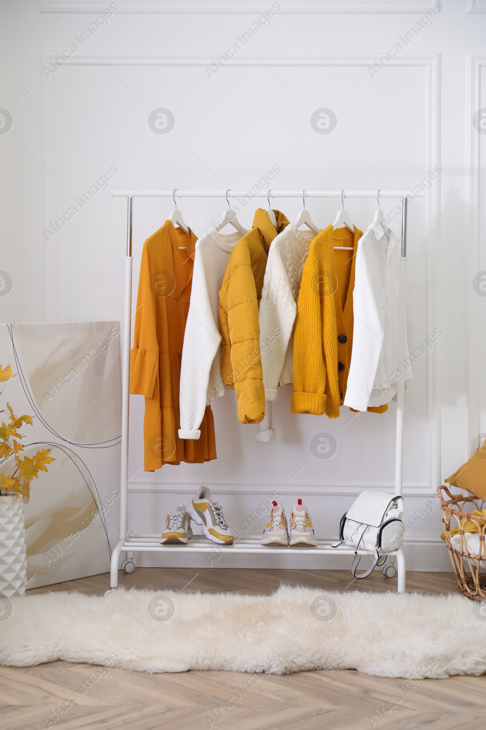 Photo of Rack with stylish warm clothes, shoes and accessories in modern dressing room