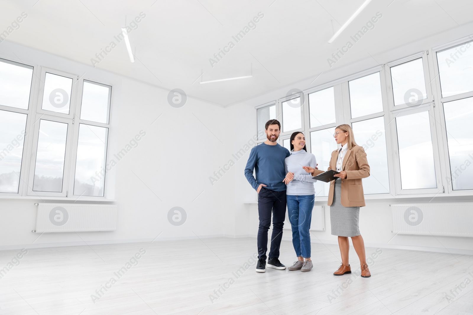 Photo of Real estate agent showing new apartment to couple