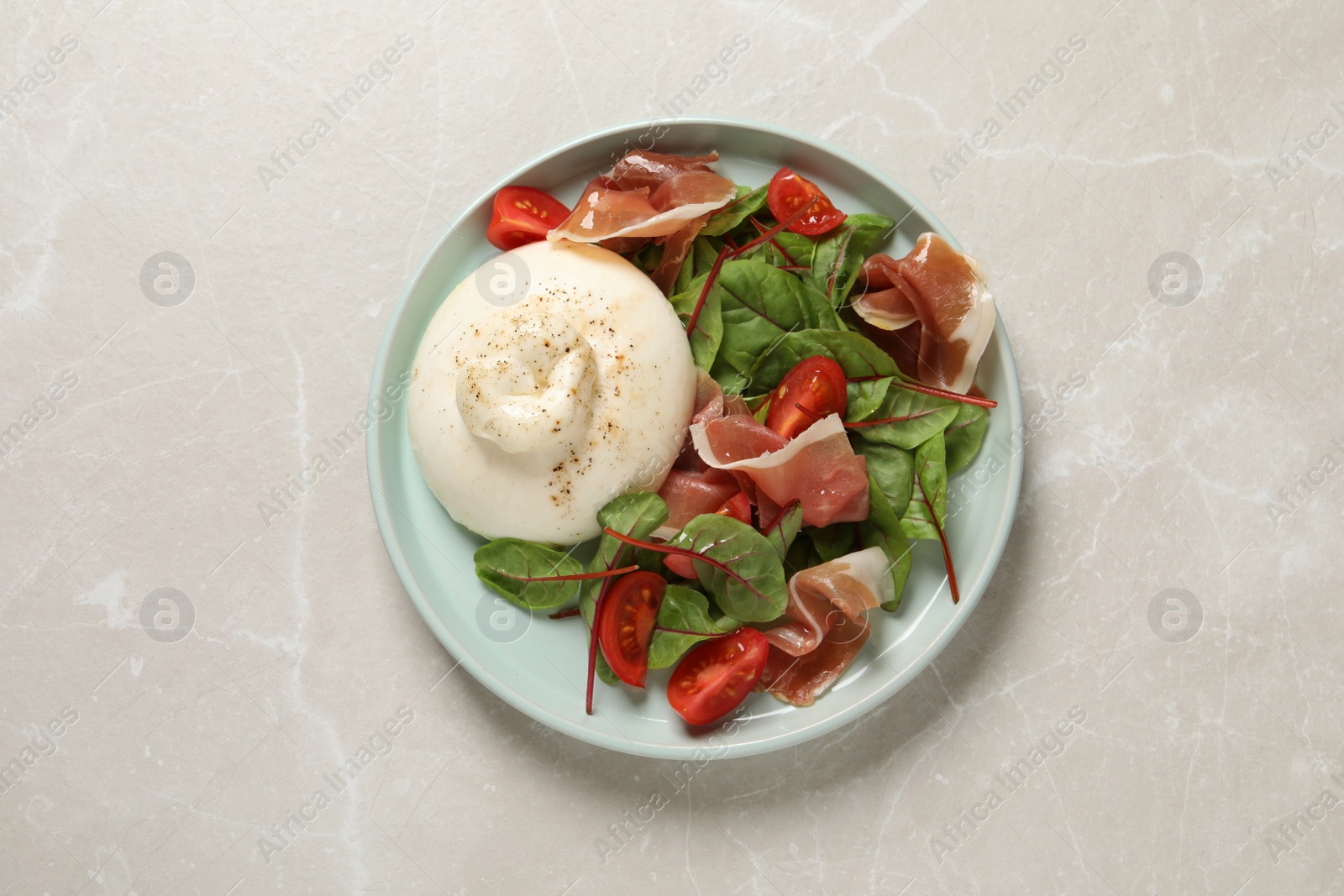 Photo of Delicious burrata salad on light grey marble table, top view