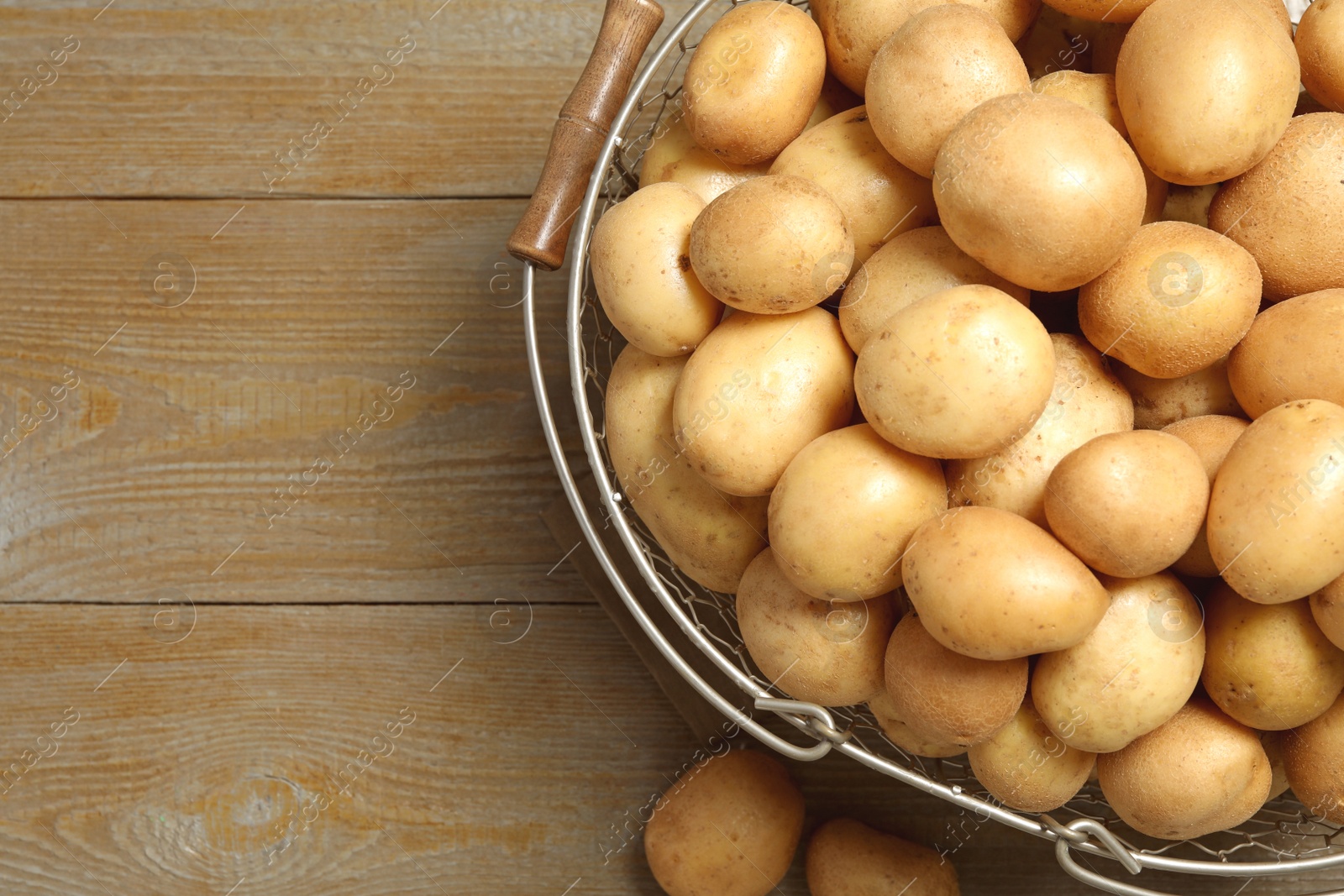 Photo of Raw fresh organic potatoes on wooden background, top view. Space for text