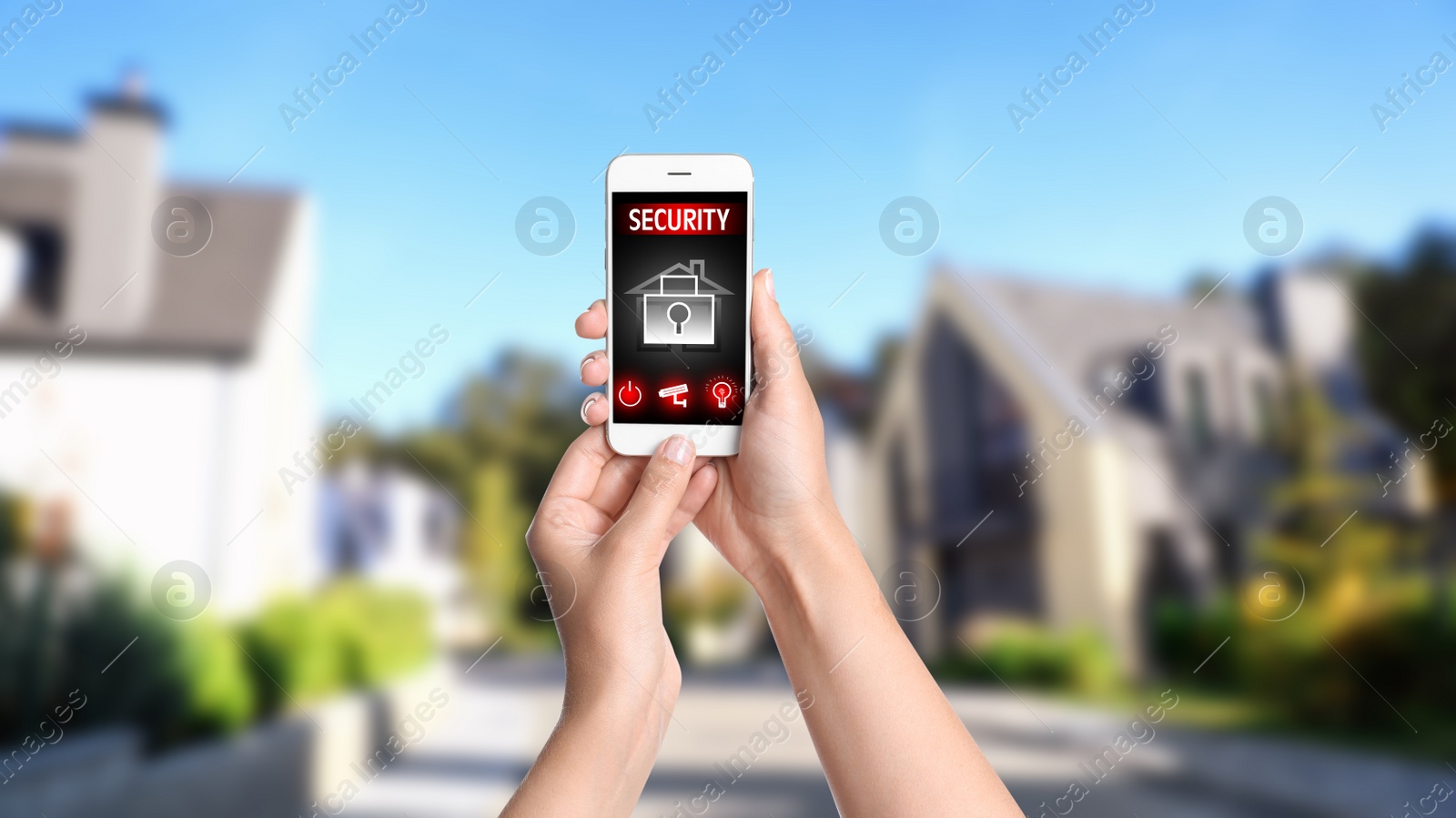 Image of Woman monitoring modern CCTV cameras on smartphone near her house, closeup. Home security system