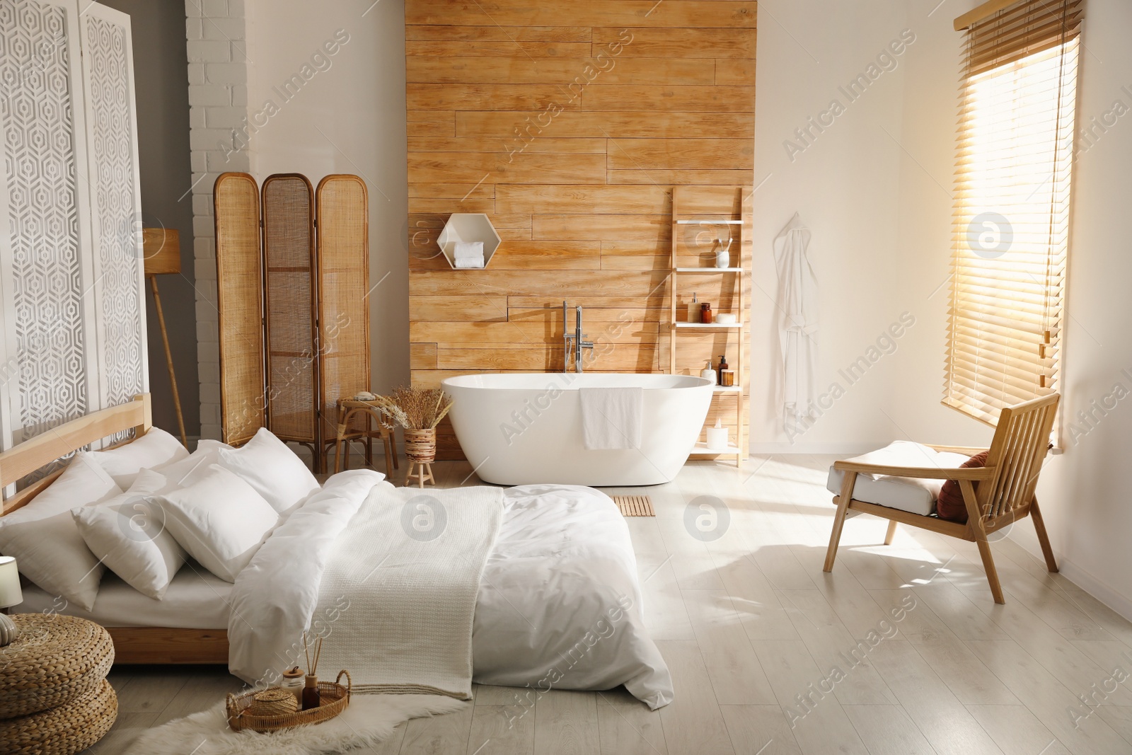 Photo of Stylish apartment interior with white bathtub and bed