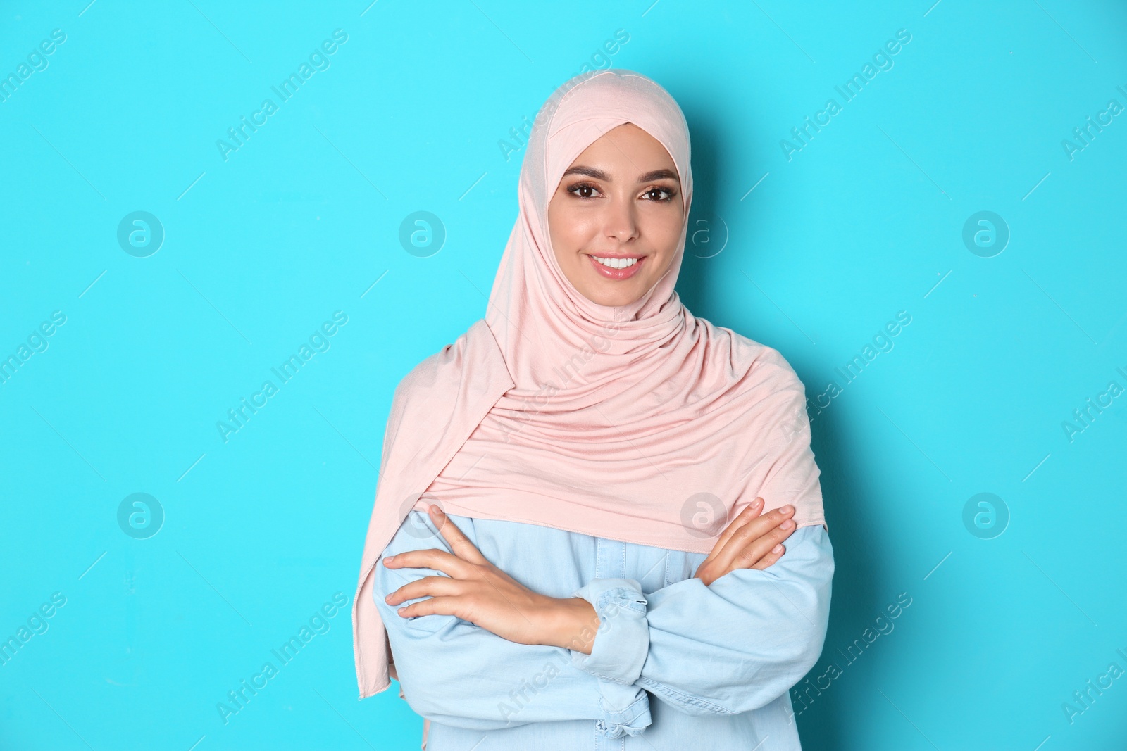 Photo of Portrait of young Muslim woman in hijab against color background