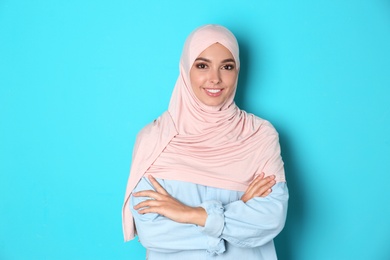 Photo of Portrait of young Muslim woman in hijab against color background