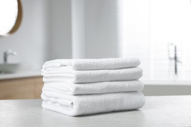 Photo of Stack of white towels on table in bathroom