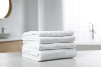 Stack of white towels on table in bathroom