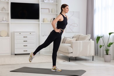 Happy woman doing morning exercise at home