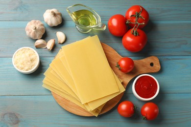 Photo of Ingredients for lasagna on blue wooden table, flat lay