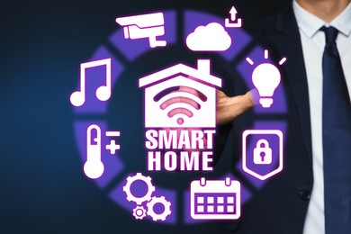 Image of Man using digital screen with Smart Home interface on dark blue background, closeup